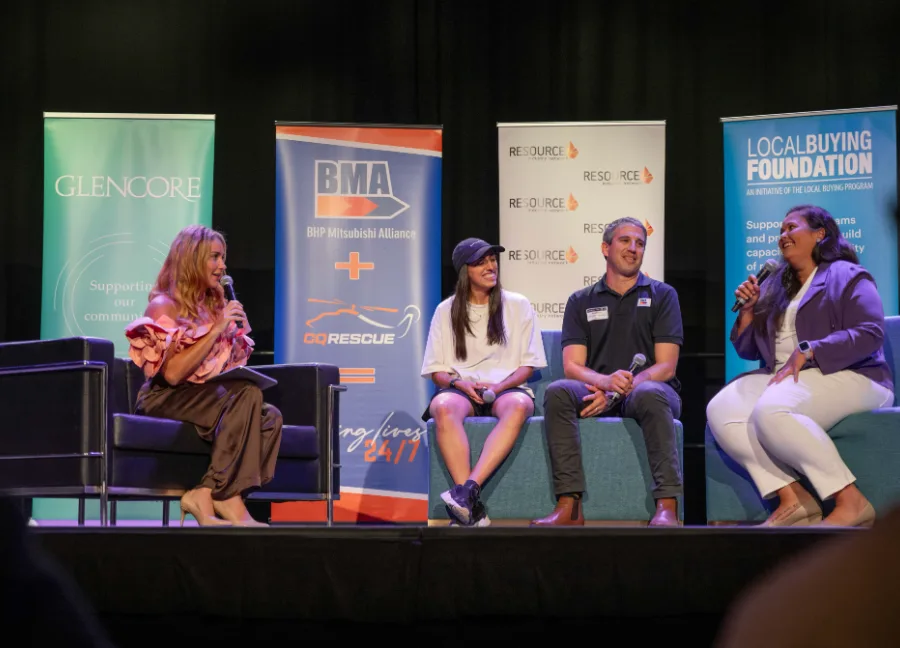 A panel discussion on stage at a Mackay industry event, with Glencore, BMA and Local Buying Foundation banners behind the panellists