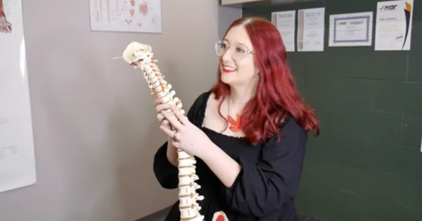 A practitioner at Anderson Family Chiropractic holding a model of the spine